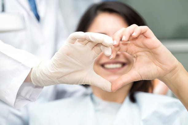 Smiling woman making a heart shape with her hands, representing heart health